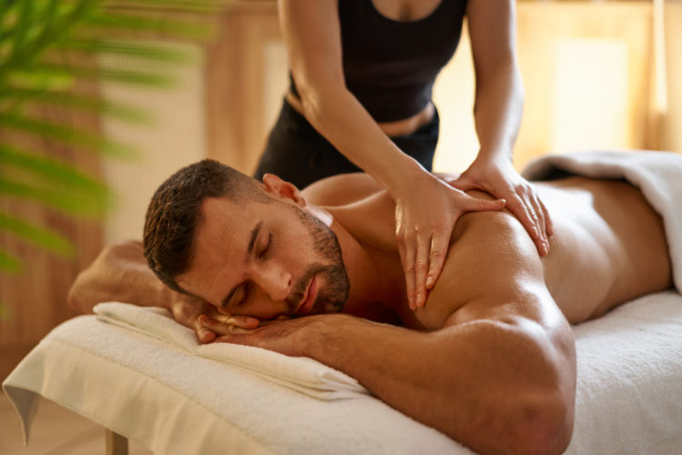 Young man having a massage by a professional masseuse